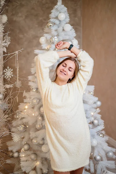 Młoda Kobieta Białym Swetrze Pokoju Ozdobionym Boże Narodzenie Stoi Tle — Zdjęcie stockowe