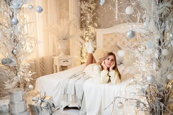 Una Mujer Joven Suéter Blanco Dormitorio Decorado Para Navidad Sobre —  Fotos de Stock