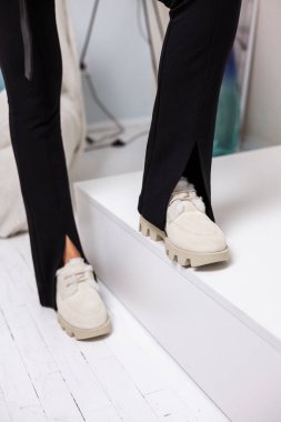 Kadınların sonbahar bej renkli güzel bacaklı süet çizmeleri. Doğal malzemelerden yapılmış şık kadın ayakkabıları.