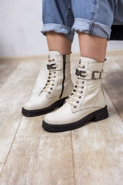 Deri çizmeler ve kot pantolonlar içinde güzel kadın bacakları. Şık çizmeli kadın bacakları.