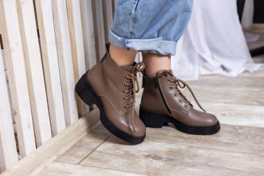 Deri çizmeler ve kot pantolonlar içinde güzel kadın bacakları. Şık çizmeli kadın bacakları.