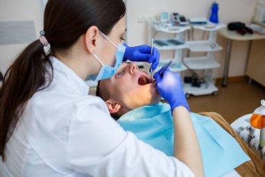 Doktor kadın diş hekimi hastanın dişlerini tedavi eder, düzgün diş bakımı yapar. Diş sağlığı ve hijyen konsepti. Seçici odak.