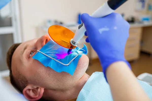 Dentysta Leczy Mężczyznę Narzędziami Dentystycznymi Dentysta Bada Zęby Pacjentów Klinice — Zdjęcie stockowe