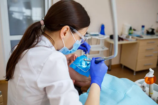 Dentysta Leczy Mężczyznę Narzędziami Dentystycznymi Dentysta Bada Zęby Pacjentów Klinice — Zdjęcie stockowe
