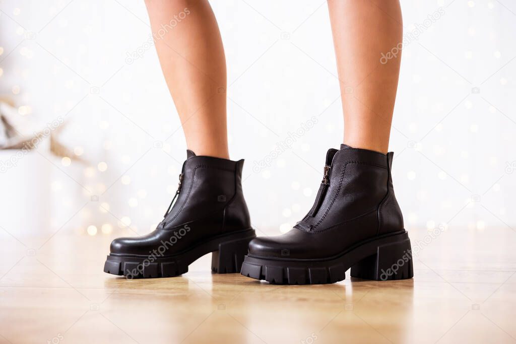 New collection of women's shoes fall-winter 2022. The girl bought new shoes. Legs in black boots.