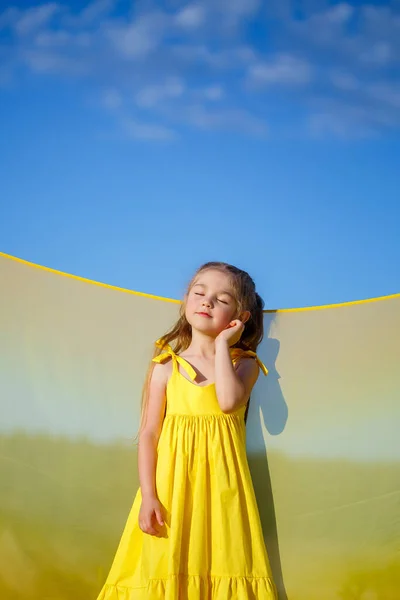 Uma Menina Loira Anos Vestido Amarelo Brilhante Contra Céu Azul — Fotografia de Stock