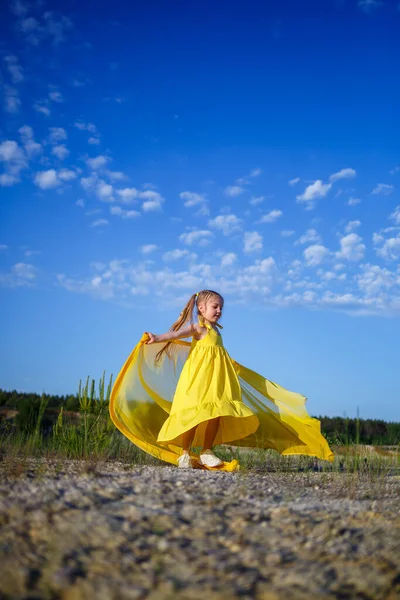 在大自然中穿着黄色夏装的可爱的卷曲的金发姑娘 — 图库照片