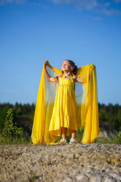 漂亮的金发姑娘穿着黄色的衣服打扮在自然界中 夏天的照片蓝天阳光灿烂 — 图库照片