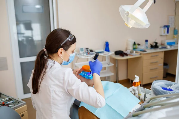 Een tandarts behandelt een mannelijke patiënt met tandheelkundige instrumenten. De tandarts onderzoekt de tanden van de patiënten in de tandheelkundige kliniek. Selectieve focus — Stockfoto