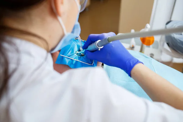 Dentysta leczy mężczyznę narzędziami dentystycznymi. Dentysta bada zęby pacjentów w klinice dentystycznej. Skupienie selektywne — Zdjęcie stockowe
