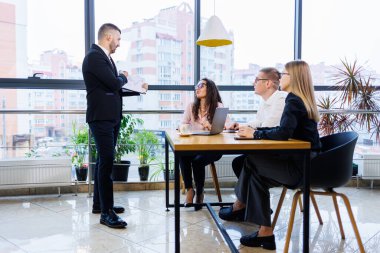Patron çizelgelerle ayakta duruyor, istatistikleri gösteriyor, eğitime katılan çeşitli personeli gösteriyor, şirketin yeni ürünlerini tanıtıyor, ortaklar için yapılan çalışmaların sonuçları hakkında raporlar sunuyor..