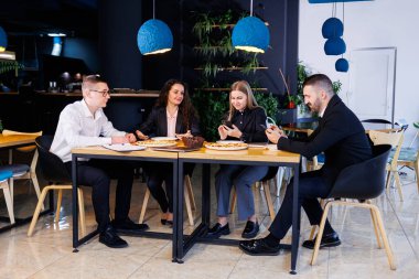 Genç tasarımcılar öğle yemeğinde ortaklarıyla yeni proje fikirlerini tartışıyor. İşadamları ofiste yeni bir iş projesini tartışıyorlar..