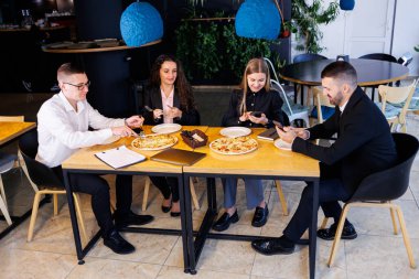 Genç tasarımcılar öğle yemeğinde ortaklarıyla yeni proje fikirlerini tartışıyor. İşadamları ofiste yeni bir iş projesini tartışıyorlar..