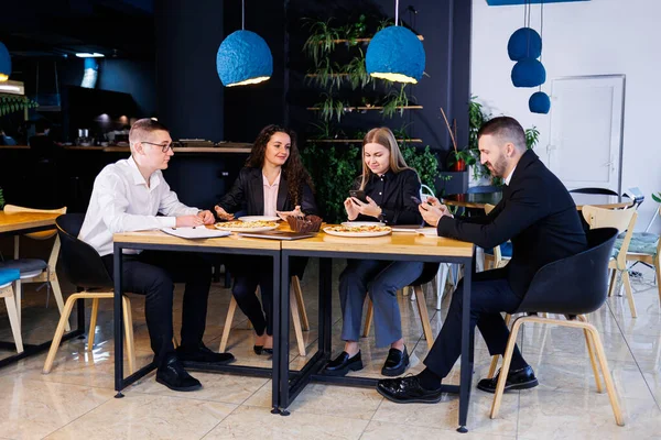 Genç tasarımcılar öğle yemeğinde ortaklarıyla yeni proje fikirlerini tartışıyor. İşadamları ofiste yeni bir iş projesini tartışıyorlar..