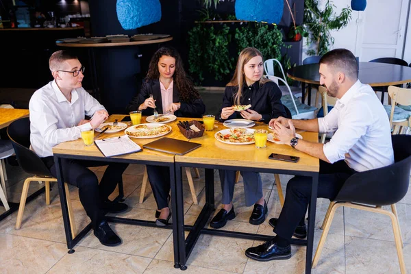 Genç tasarımcılar öğle yemeğinde ortaklarıyla yeni proje fikirlerini tartışıyor. İşadamları ofiste yeni bir iş projesini tartışıyorlar..