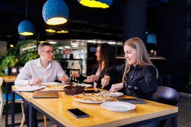 Genç tasarımcılar öğle yemeğinde ortaklarıyla yeni proje fikirlerini tartışıyor. İşadamları ofiste yeni bir iş projesini tartışıyorlar..
