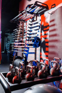 Farklı renklerde kettlebell 'ler. Spor salonundaki spor aletleri. Beden eğitimi için kettlebell. Spor salonunda sıralanmış ağırlık atışları..