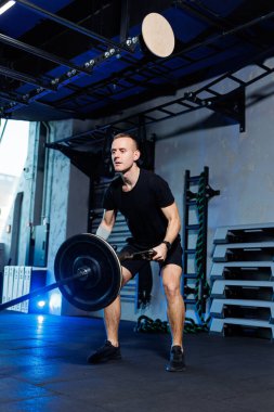 Egzersiz yapan ve spor salonunda ağırlık kaldıran çekici bir yetişkin. Spor salonunda spor eğitimi.