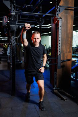 Modern spor salonunda kaslı adam ağır egzersizler yapıyor. Spor salonunda spor.