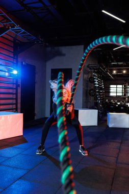 Sportif bir kadın spor malzemelerini kullanarak egzersiz yapar. İp, spor salonuna gider..