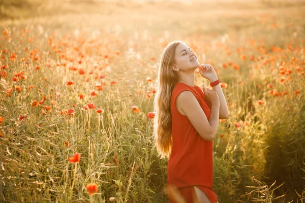 ポピーの花の分野で赤いドレスを着た美しい女性 選択的焦点 — ストック写真