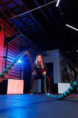 Sportif bir kadın spor malzemelerini kullanarak egzersiz yapar. İp, spor salonuna gider..