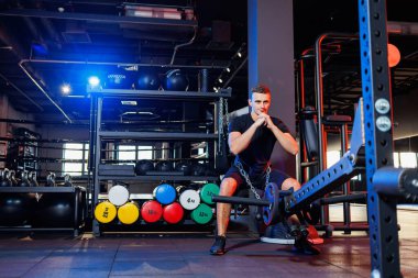Yakışıklı kaslı adam spor salonunda ağır egzersizler yapıyor. Sağlıklı yaşam tarzı