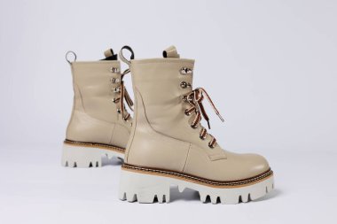 İzole edilmiş beyaz stüdyo arka planında hakiki deri ayakkabıları olan güzel bej ayakkabılar. Modaya uygun klasik kadın çizmeleri. Zarif, zarif deri ayakkabılar..