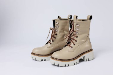 İzole edilmiş beyaz stüdyo arka planında hakiki deri ayakkabıları olan güzel bej ayakkabılar. Modaya uygun klasik kadın çizmeleri. Zarif, zarif deri ayakkabılar..