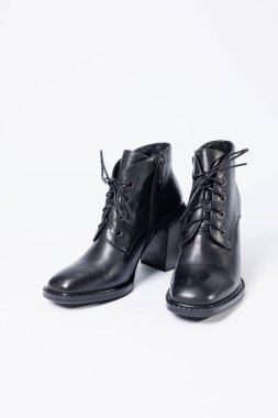 Beyaz bir arka planda izole edilmiş siyah, hakiki deri topuklu kadın botları. Yandan, çapraz ve arkadan çekilmiş bir fotoğraf. Kadın ayakkabı koleksiyonu 2022