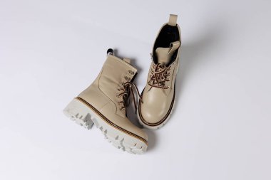 İzole edilmiş beyaz stüdyo arka planında hakiki deri ayakkabıları olan güzel bej ayakkabılar. Modaya uygun klasik kadın çizmeleri. Zarif, zarif deri ayakkabılar..