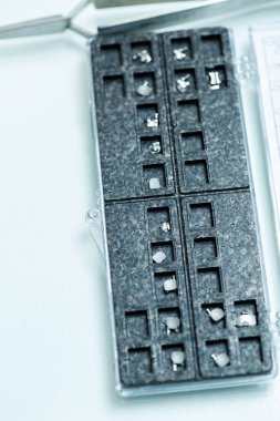 Metal teller, dişlerin üzerine yapıyı bir ortodontistin ellerine takmak için. Ortodontist elinde yeni diş telleri tutuyor ve bir diş kliniğinde bir hasta için hazırlıyor.,