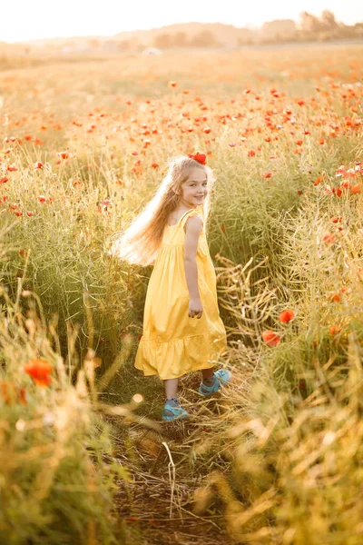 Menina Vestido Amarelo Corre Flores Papoula Vermelhas Fundo Grama Verde — Fotografia de Stock