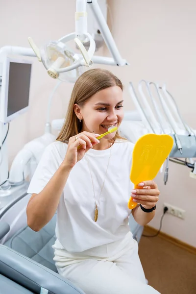 Beautiful Woman White Shirt Sits Dental Office Looks Mirror Smiles — Stock Photo, Image