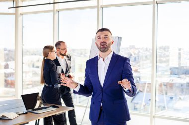 Başarılı bir erkek akıl hocası, yönetmen, ofiste takım elbiseli bir iş adamı. Çalışma günü konsepti. Ön planda patronla takım toplantısı var.