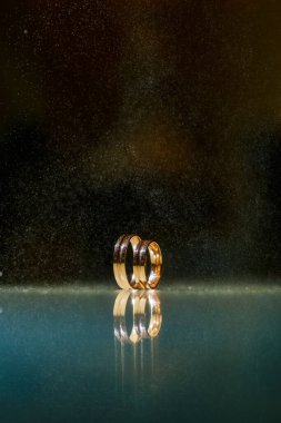 Su damlacıklı alyanslar, nişan yüzüğü, alyansları ve yıldızları olan güzel gümüş arka plan.
