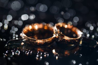 Su damlacıklı alyanslar, nişan yüzüğü, alyansları ve yıldızları olan güzel gümüş arka plan.