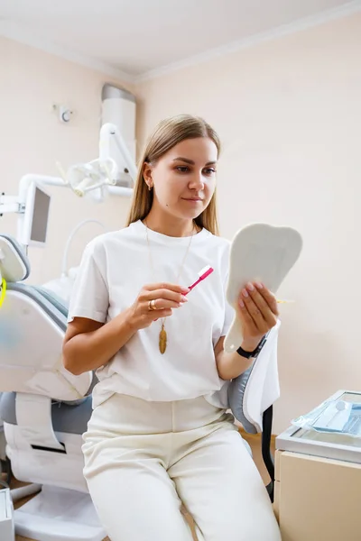 Beautiful Woman White Shirt Sits Dental Office Looks Mirror Smiles — Stock Photo, Image