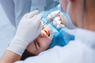 Diş hekimi diş malzemesi kullanarak hastanın dişlerini muayene eder. Modern tıbbi ekipmanlar. Lokal anestezi ile dişlerin anestezisi. Oral tedavi kavramı. Yakın plan. Seçici odak.