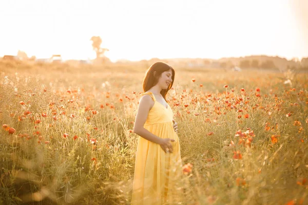 夏天的一天 穿着黄色衣服的美丽的年轻女子在罂粟田里散步 在乡间欣赏花朵的女孩 有选择的重点 — 图库照片