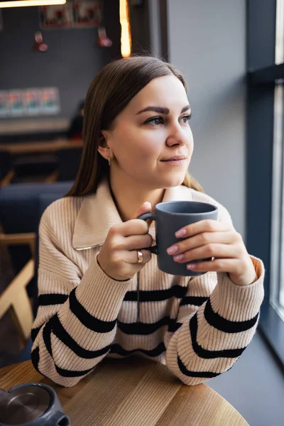 Uma Jovem Mulher Bonita Bebe Café Olha Pela Janela Enquanto — Fotografia de Stock