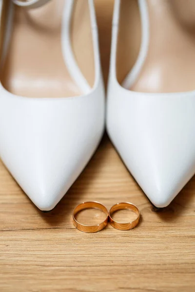 Gouden Ringen Van Pasgetrouwden Tussen Witte Schoenen Met Hakken Kostbare — Stockfoto
