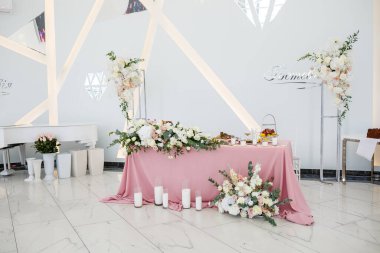 Yeni evliler için düğün masası dekoru. Taze çiçeklerle süslenmiş.