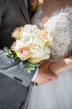 Gelinin elleri bir buket taze güzel çiçekle yakın çekim. Gelinin Özniteliği