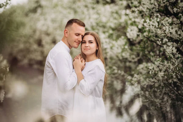 Jonge Liefhebbende Koppel Een Wandeling Een Lente Bloeiende Appelboomgaard Gelukkig — Stockfoto