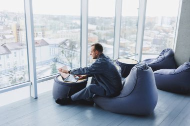 Ayrıl. Sırıtkan genç adam masada oturmuş laptopla rahatlarken arkana yaslan, işten zevk al, tatmin ol.
