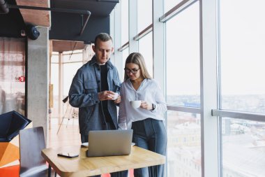 Bir dizüstü bilgisayarın arkasında iki genç girişimci ofiste sunum izleyip şirketin kalkınma planını tartışıyor. Genç yönetici, astından yöneticiye nasıl not tutacağını söyler.
