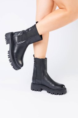 Gerçek deriden yapılmış kadınların siyah bahar çizmeleri çıplak ayakla giyilir.