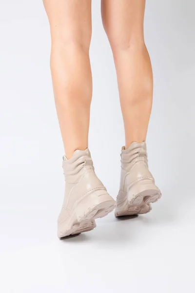 女性の足でベージュ革の靴で新しいコレクションから白い背景女性の足でファッショナブルな靴で作られたエコ革春2022 — ストック写真