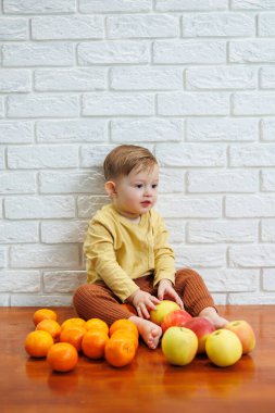 Gülümseyen çocuk taze, sulu bir kırmızı elma yer. Küçük çocuklar için sağlıklı meyveler. Çocuk meyve ve sebze yiyor..